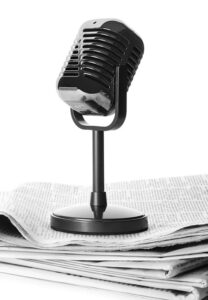vintage microphone standing atop a newspaper2 pile 2026 03 09 02 54 04 utc